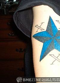 手臂上的蓝色和黑色相间的五芒星纹身