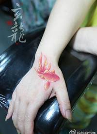 女生手部潮流经典的彩色小金鱼纹身图案