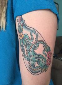 女性左手臂上漂流瓶里的绿色章鱼和花纹身图片