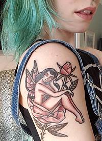 美女右手臂上彩色的玫瑰花和蝴蝶仙子纹身图片