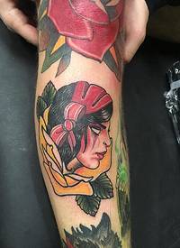 花臂膀上的红色和黄色玫瑰花里的女子肖像纹身