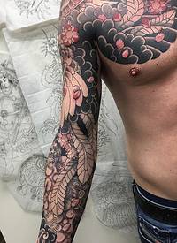男生手臂上彩绘抽象线条花朵和羽毛花臂纹身图片