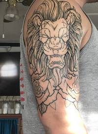 男生大臂上黑色简单抽象线条花朵和小动物狮子纹身图片